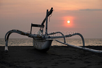 Senggigi  Indonesien  Jukung steht bei Sonnenuntergang am Strand. Ein Jukung ist ein traditionelles indonesisches Fischerboot