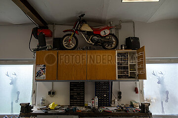 Deutschland  Heidenau - private Werkstatt mit einem Gelaendemotorrad fuer Kinder auf dem Schrank