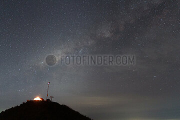 Senaru  Indonesien  Licht scheint in der Nacht in einem Zelt unter dem Sternenhimmel auf einem Huegel des Mount Rinjani