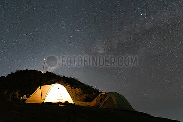 Senaru  Indonesien  Licht scheint in der Nacht in einem Zelt unter dem Sternenhimmel auf dem Mount Rinjani