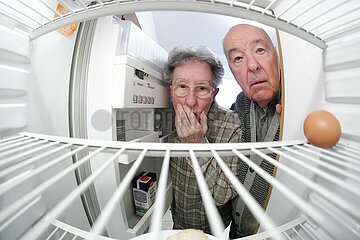 Rentner sehen in leeren Kuehlschrank