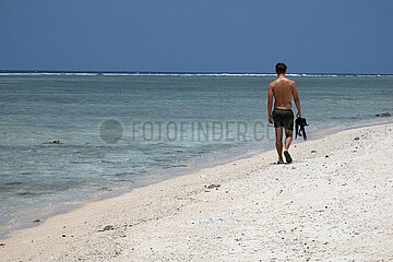 Gili Trawangan  Indonesien  junger Mann laeuft am Strand entlang