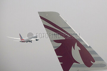 Doha  Katar  Detailaufnahme: Heckfluegel eines Flugzeugs der Qatar Airways und startendes Flugzeug der American Airlines