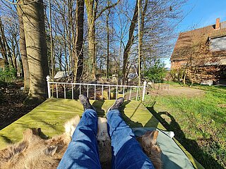 Deutschland  Heidenau - Mann entspannt auf einem schwebenden Bett im Garten auf dem Land