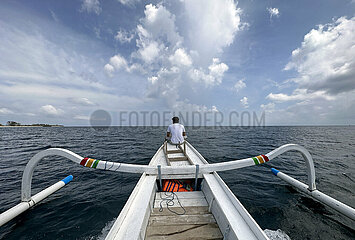 Senggigi  Indonesien  Mann sitzt am Bug eines Jukung. Ein Jukung ist ein traditionelles indonesisches Fischerboot