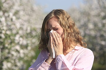 Frau mit Heuschnupfen niest