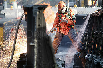 Berlin  Deutschland  Bauarbeiter schweisst einen Teil einer abgerissenen Eisenbahnbruecke auseinander