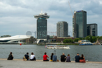 Niederlande  Amsterdam - Menschen entspannen am Wasser  Blick von der Rueckseite von Centraal Station auf die Amstel