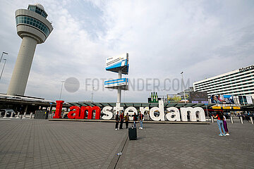Niederlande  Amsterdam - Passagiere vor dem slogan I amsterdam im Aussenbereich des Amsterdam Airport Schiphol (AMS)
