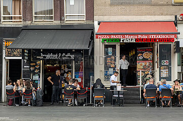 Niederlande  Amsterdam - zwei konkurriende  auf ankommende Touristen spezialisierte Cafe-Restaurants auf der Damrak im Stadtteil Centrum