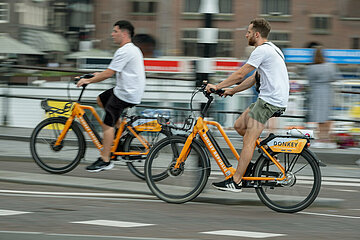Niederlande  Amsterdam - Fahrradfahrer auf Mietfahrraedern im Stadtzentrum