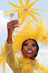 Ascot  Grossbritannien  elegant gekleidete Frau mit Hut macht von sich beim Pferderennen Royal Ascot ein Selfie