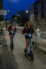 Polen  Poznan - Zwei junge Frauen auf e-scootern auf Haupstrasse im Stadtteil Wilda