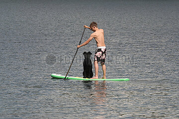 Lanken  Polen  Teenager beim Stand-Up-Paddling mit seinem Hund