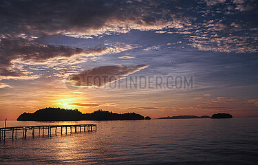 Togianinseln  Sulawesi  Indonesien  Malerischer Sonnenuntergang ueber einem paradiesischen Palmenstrand einer tropischen Insel