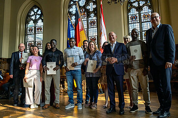 Deutschland  Bremen - Einbuergerungsfeier in der in der Oberen Rathaushalle  im Bild Neubuerger mit der Einbuergerungsurkunde  rechts Bundeskanzler Olaf Scholz  ganz rechts Bremer Buergermeister Andreas Bovenschulte