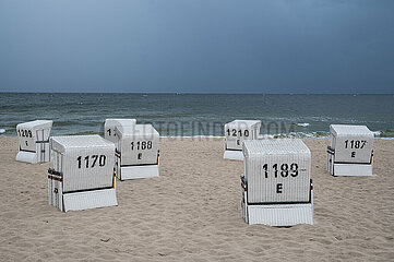 Heringsdorf  Usedom  Dunkler Himmel ueber leeren Strandkoerben am Seebad entlang der Ostsee