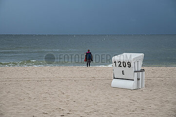 Heringsdorf  Usedom  Eine Frau steht am Ufer des Ostseestrands und blickt aufs Wasser