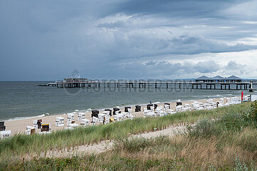 Heringsdorf  Usedom  Dunkle Wolken ziehen ueber den leeren Sandstrand mit der Seebruecke im Hintergrund