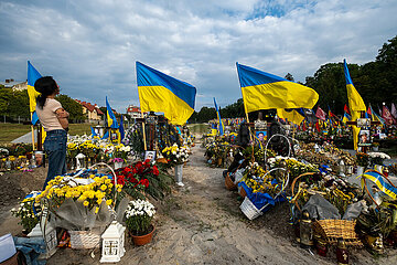 Ukraine  Lwiw - Witwe trauert am Grab ihres Manns auf dem Marsfeld  Ehrenfriedhof der gefallenen Lwiwer Soldaten im Ukrainekrieg