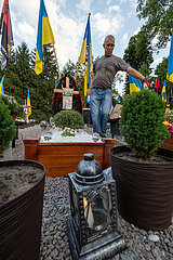 Ukraine  Lwiw - Mann am Grab seines Schwiegersohns auf dem Marsfeld  Ehrenfriedhof der gefallenen Lwiwer Soldaten im Ukrainekrieg