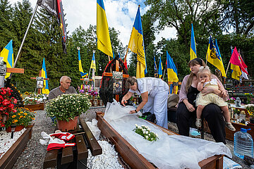 Ukraine  Lwiw - Witwe mit ihren Eltern und Tochter am Grab ihres Manns auf dem Marsfeld  Ehrenfriedhof der gefallenen Lwiwer Soldaten im Ukrainekrieg