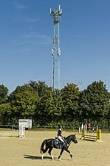 Mobilfunkmast überragt Reitplatz  sorgt für Empfang auf dem Land.