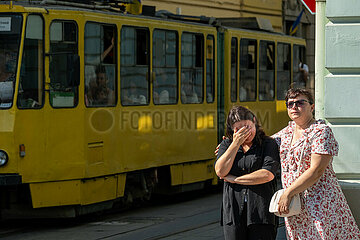 Ukraine  Lwiw - Ukrainekrieg: Strassenbahn  die fuer einen Beerdigungszug fuer zwei gefallene ukrainische Soldaten angehalten wurde. Vorne zwei traurige Frauen  eine weint