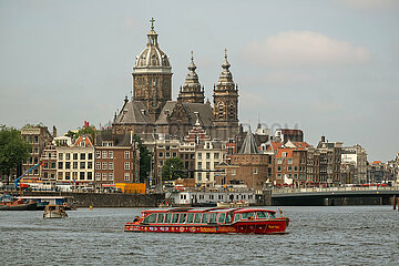 Niederlande  Amsterdam - Blick ueber den frueheren Meeresarm IJ auf die Basilika St. Nikolaus  vorne ein Ausflugsboot