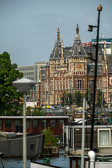 Niederlande  Amsterdam - Blick ueber den frueheren Meeresarm IJ auf die Centraal Station  vorne Hausboote