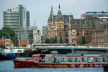 Niederlande  Amsterdam - Blick ueber den frueheren Meeresarm IJ auf die Centraal Station  vorne ein Ausflugsboot