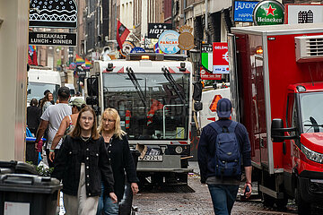 Niederlande  Amsterdam - Stadtreinigung saeubert am Morgen Gasse in der Altstadt