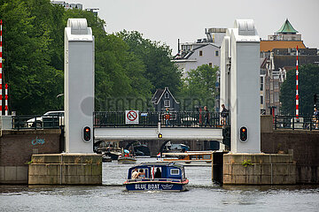 Niederlande  Amsterdam - Ausflugsboot unterquert Bruecke und Schleuse zwischen dem IJ und dem Grachtenguertel