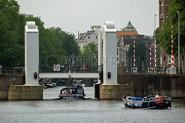 Niederlande  Amsterdam - Ausflugsboot unterquert Bruecke und Schleuse zwischen dem IJ und dem Grachtenguertel