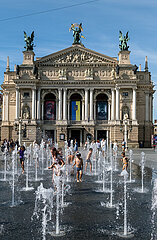 Ukraine  Lwiw - Kinder und Jugendliche erfrischen sich an Wassersauelen vor der Oper am Prospekt Svobody