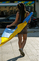 Ukraine  Lwiw - Junge Frau posiert mit ukrainischer Flagge am Unabhaengigkeitstag. Wegen des russischen Angriffskriegs gibt es keine grossen Veranstaltungen