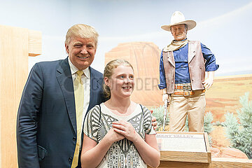 U.S. Republican presidential candidate Donald Trump poses with supporters as he tours the museum and birthplace of actor John Wayne