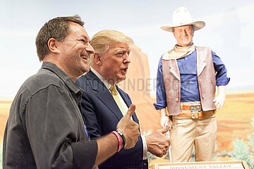 U.S. Republican presidential candidate Donald Trump poses with supporters as he tours the museum and birthplace of actor John Wayne