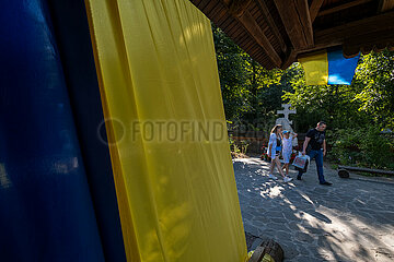 Ukraine  Lwiw - Ukrainische Fahnen an Holzkirche im Freilichtmuseum Schewtschenkiwskyj Haj mit historischen ukrainischen Baudenkmaelern