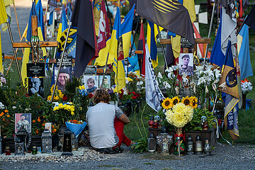 Ukraine  Lwiw - Das Marsfeld  Ehrenfriedhof der gefallenen Lwiwer Soldaten im Ukrainekrieg  Angehoerige am Grab