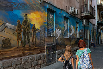 Ukraine  Lwiw - Wandbild mit Darstellung ukrainischer Soldaten und Friedenstauben in einer Gasse im Stadtzentrum thematisiert den russischen Angriffskrieg