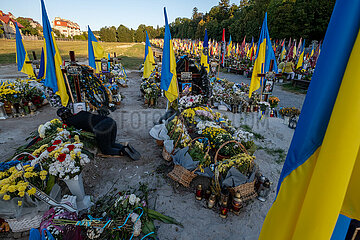 Ukraine  Lwiw - Das Marsfeld  Ehrenfriedhof der gefallenen Lwiwer Soldaten im Ukrainekrieg  Mutter wirft sich weinend auf das Grab ihres Sohnes