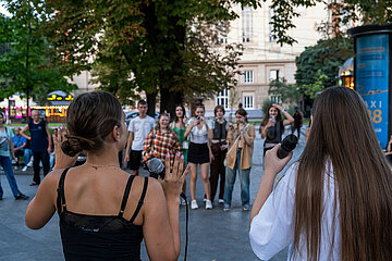 Ukraine  Lwiw - Ablenkung vom Kriegsalltag  Zwei junge Frauen singen zu ukrainischer Popmusik am Prospekt Svobody  dem wichtigsten Boulevard der Stadt