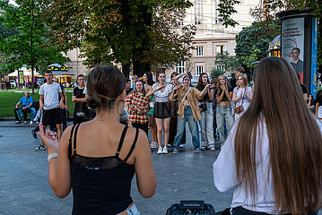 Ukraine  Lwiw - Ablenkung vom Kriegsalltag  Zwei junge Frauen singen zu ukrainischer Popmusik am Prospekt Svobody  dem wichtigsten Boulevard der Stadt