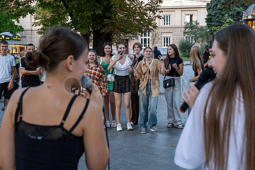 Ukraine  Lwiw - Ablenkung vom Kriegsalltag  Zwei junge Frauen singen zu ukrainischer Popmusik am Prospekt Svobody  dem wichtigsten Boulevard der Stadt