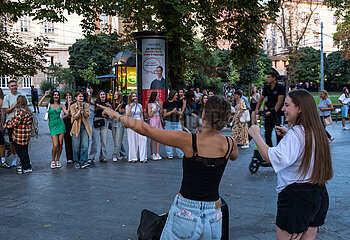 Ukraine  Lwiw - Ablenkung vom Kriegsalltag  Zwei junge Frauen singen zu ukrainischer Popmusik am Prospekt Svobody  dem wichtigsten Boulevard der Stadt