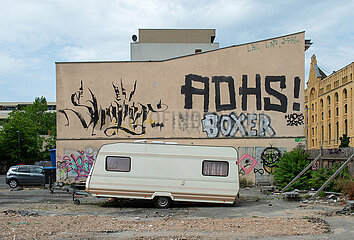 Berlin  Deutschland - Bespruehte Hauswand mit Wohnwagen
