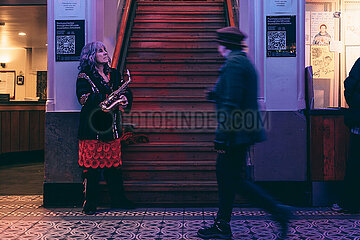 A musician waits to play with her band in the lobby.