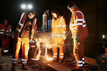 Berlin  Deutschland - Facharbeiter einer Gleisbaufirma beim Thermit-Schweissen von zwei Gleisen am Tunnelzulauf zum Tiefgeschoss des Berliner Hauptbahnhofes.