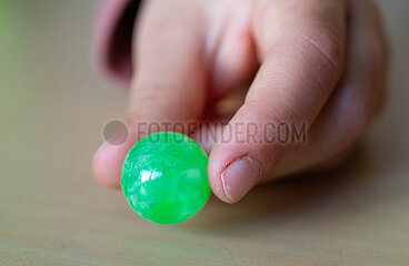 Berlin  Deutschland - Kinderhand mit gruener Glasmurmel